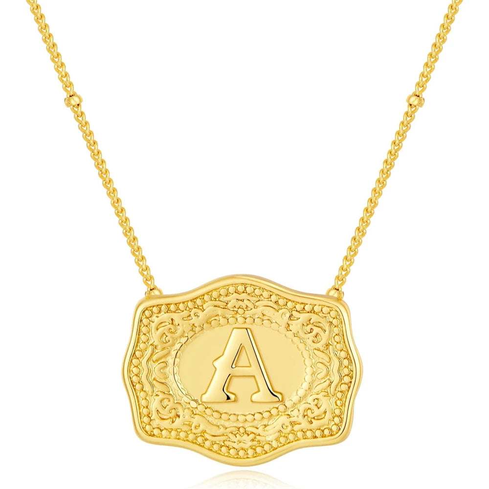Gold necklace with a decorative pendant featuring the letter 'A' on a white background